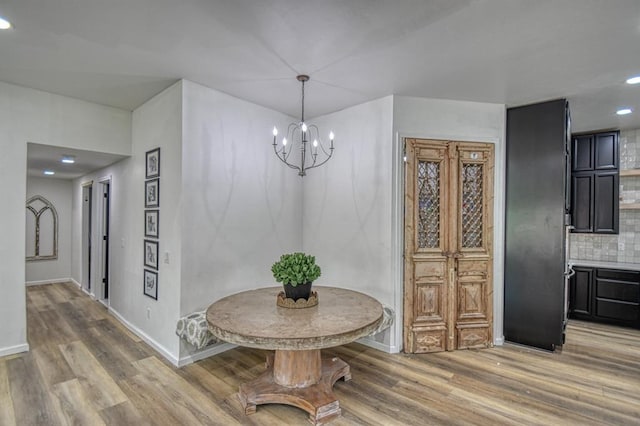 dining room with hardwood / wood-style flooring and a notable chandelier