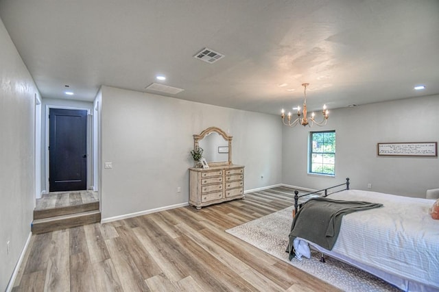 bedroom with an inviting chandelier and light hardwood / wood-style floors