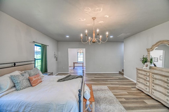 bedroom featuring a notable chandelier and light wood-type flooring