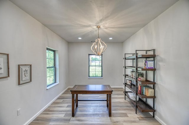 unfurnished office with a chandelier and light hardwood / wood-style flooring