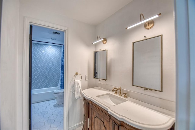 full bathroom featuring tiled shower / bath combo, vanity, tile patterned floors, and toilet