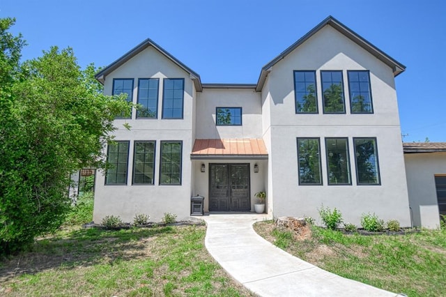 view of front of house with french doors and a front lawn