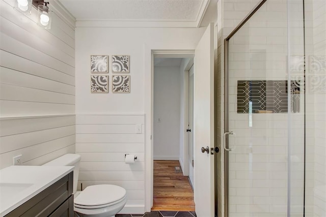 full bathroom with vanity, ornamental molding, a shower stall, and toilet