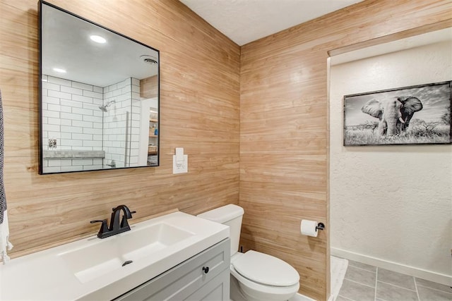 full bath featuring toilet, vanity, baseboards, tile patterned floors, and walk in shower