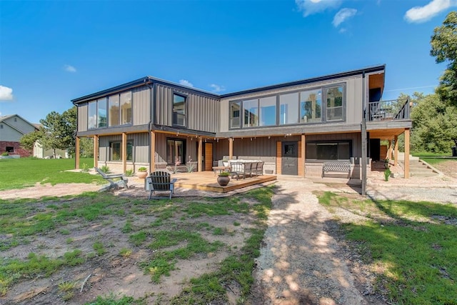 back of house featuring outdoor lounge area and a yard