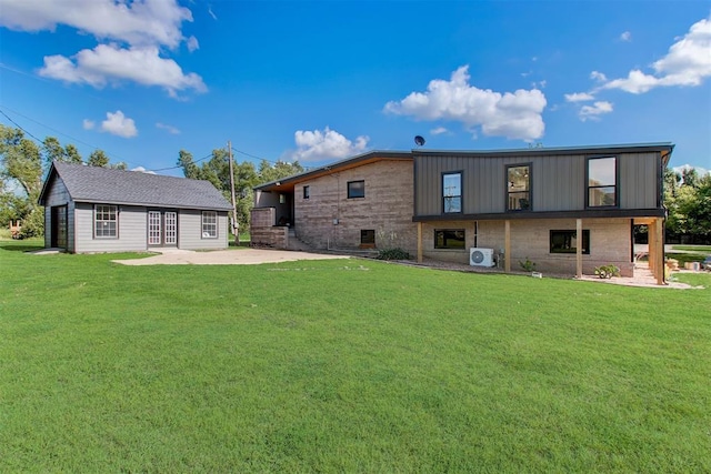 back of property featuring an outbuilding, a patio, a lawn, and ac unit