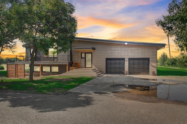 contemporary house featuring an attached garage, driveway, and brick siding