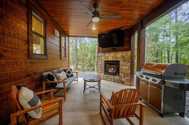 view of patio / terrace with an outdoor living space with a fireplace, grilling area, and ceiling fan