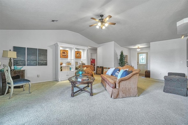 carpeted living room featuring a textured ceiling, vaulted ceiling, and ceiling fan