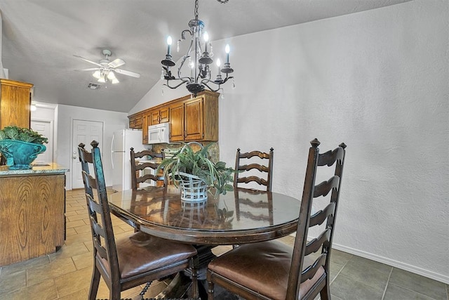 tiled dining space with ceiling fan with notable chandelier and vaulted ceiling