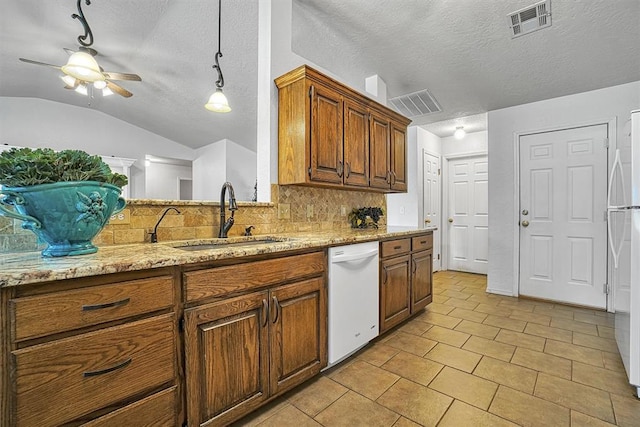 kitchen with a textured ceiling, white appliances, ceiling fan, sink, and lofted ceiling