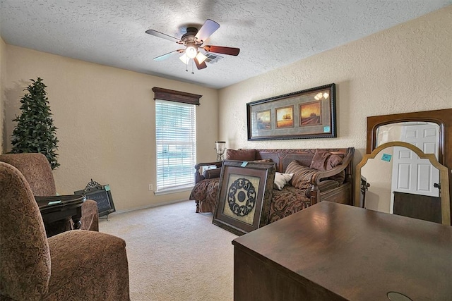 living room featuring ceiling fan, light colored carpet, and a textured ceiling