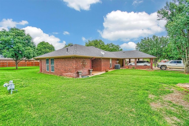 rear view of house featuring a lawn, a carport, and central air condition unit