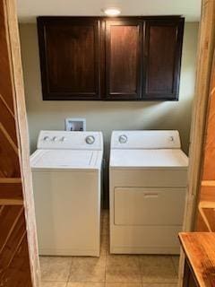 washroom with cabinets, washing machine and dryer, and light tile patterned floors