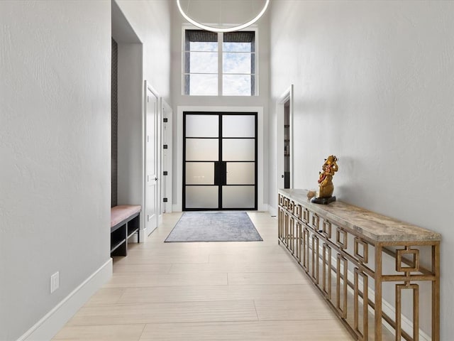 foyer entrance featuring a high ceiling and light wood-type flooring