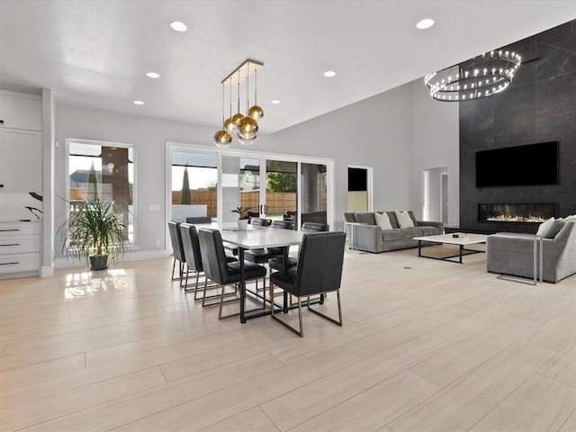 dining area with a tile fireplace and light wood-type flooring