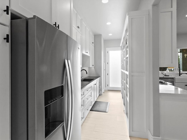 kitchen with white cabinets, stainless steel refrigerator with ice dispenser, and sink