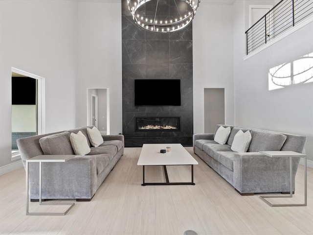 living room featuring a towering ceiling and light hardwood / wood-style floors