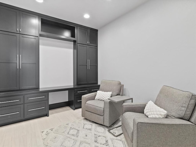 sitting room featuring built in desk and light wood-type flooring