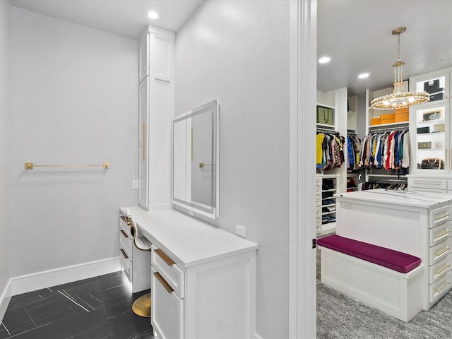 spacious closet with an inviting chandelier