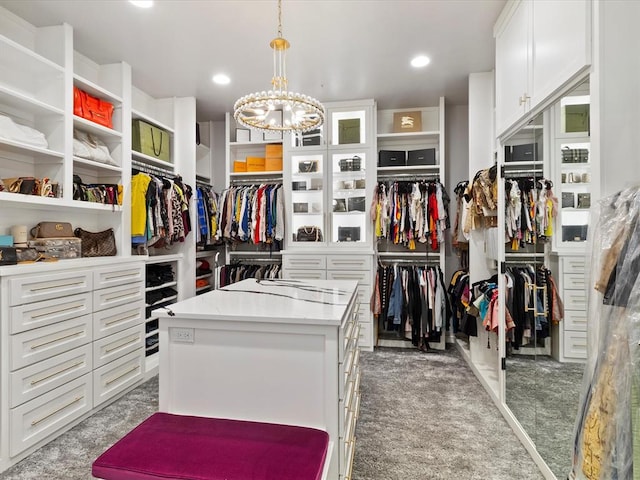 spacious closet with carpet flooring and an inviting chandelier