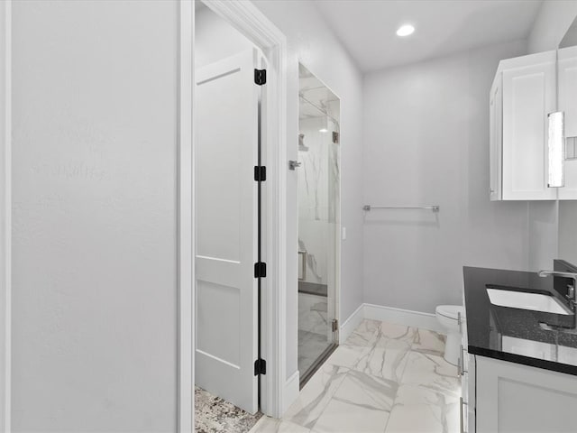 bathroom featuring toilet, an enclosed shower, and vanity