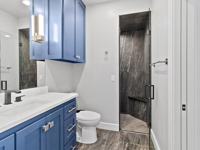 bathroom with vanity, toilet, and a shower with door