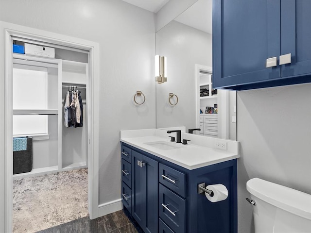 bathroom with hardwood / wood-style flooring, vanity, and toilet