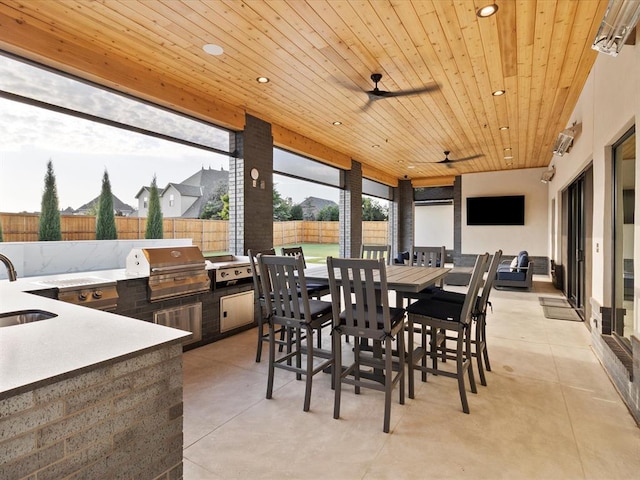 exterior space featuring ceiling fan, area for grilling, a wet bar, and grilling area