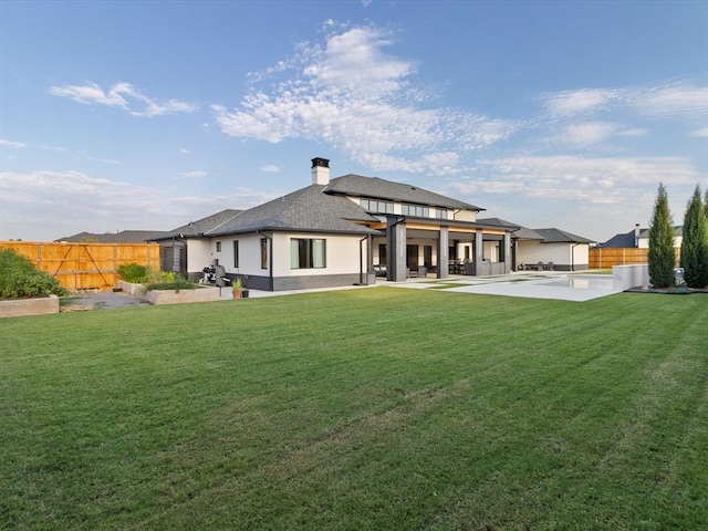 rear view of house with a yard and a patio