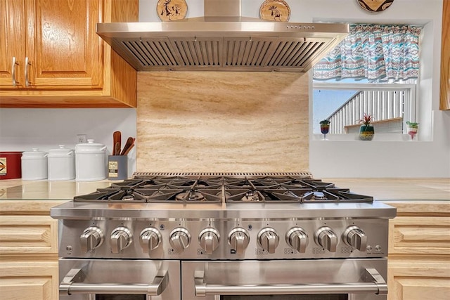 kitchen featuring high end stove and wall chimney range hood