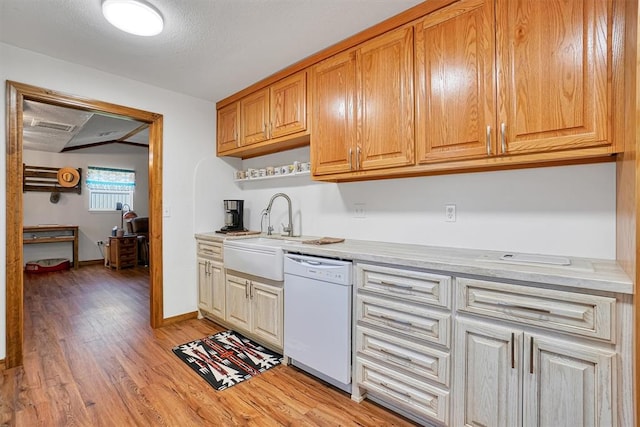 kitchen featuring dishwasher, a textured ceiling, light wood-type flooring, and sink