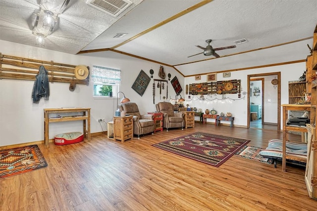 living room with ornamental molding, a textured ceiling, vaulted ceiling, ceiling fan, and hardwood / wood-style floors