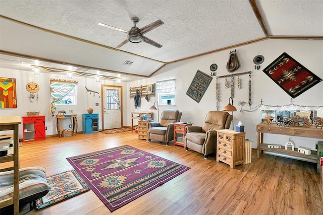 living room with a textured ceiling, ceiling fan, hardwood / wood-style floors, and lofted ceiling