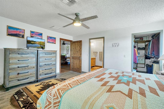 bedroom featuring ceiling fan, a closet, wood-type flooring, and a textured ceiling