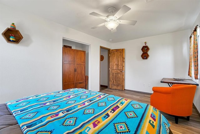 bedroom with ceiling fan, wood-type flooring, and a closet