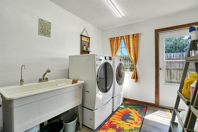 laundry room with washing machine and dryer and light hardwood / wood-style flooring