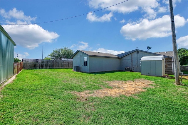 view of yard with central AC unit and a storage shed