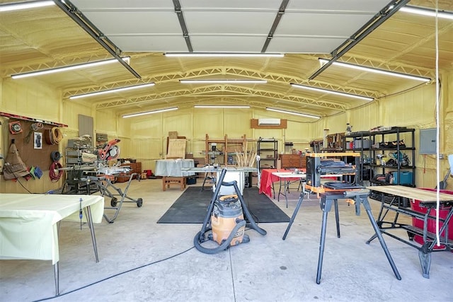 garage with a workshop area and electric panel