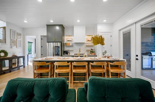 45 Pecan Trace Trl, Broken Bow, OK 74728 - kitchen with gray cabinets, a kitchen breakfast bar, light hardwood / wood-style floors, stainless steel refrigerator, and french doors
