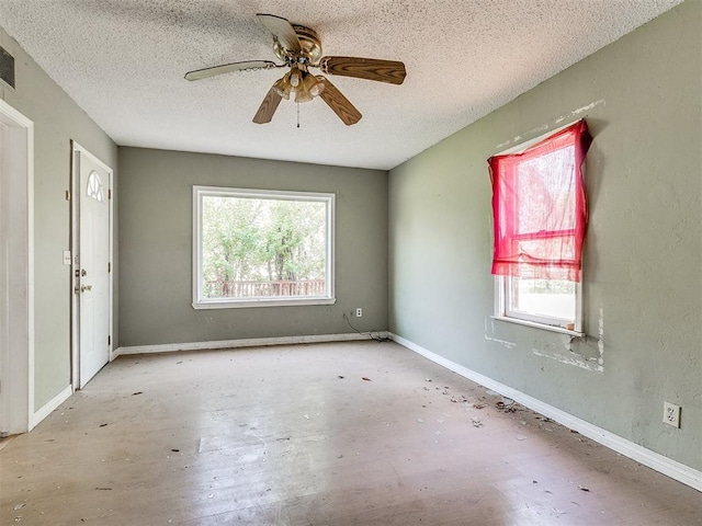 empty room featuring ceiling fan and a textured ceiling