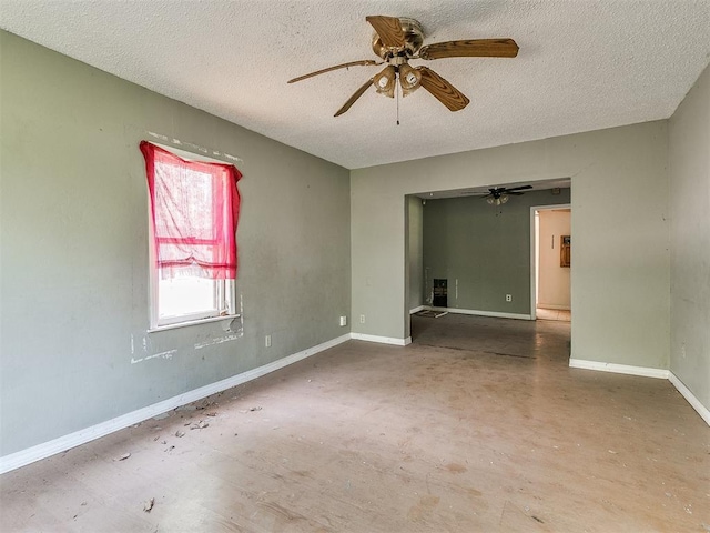 unfurnished room with ceiling fan and a textured ceiling