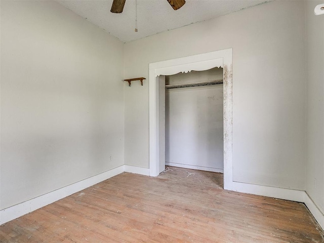 unfurnished bedroom featuring light hardwood / wood-style floors, a closet, and ceiling fan