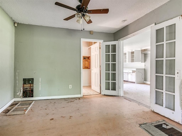 empty room featuring ceiling fan, a textured ceiling, and french doors