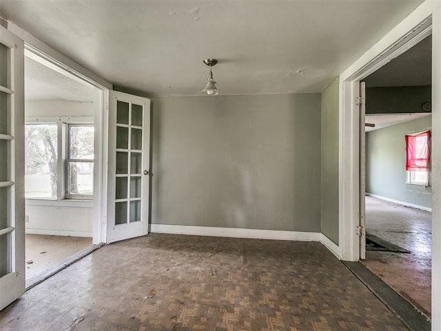 unfurnished dining area featuring french doors and dark parquet flooring