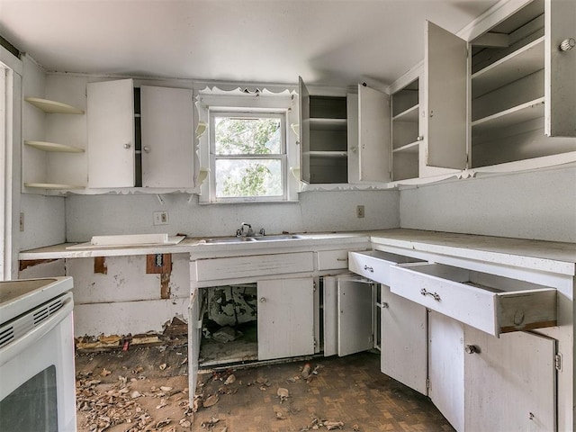 kitchen with dark parquet flooring, electric range, sink, and white cabinets