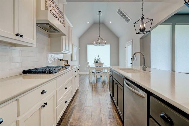 kitchen with dark wood-type flooring, white cabinets, sink, decorative light fixtures, and stainless steel appliances