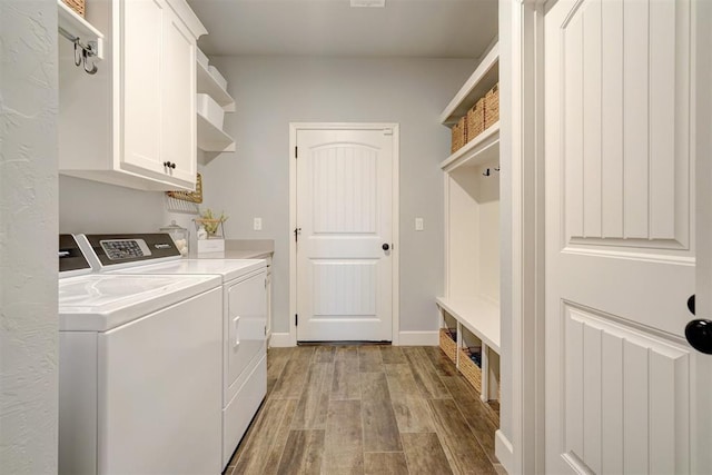 clothes washing area featuring cabinets, independent washer and dryer, and light wood-type flooring