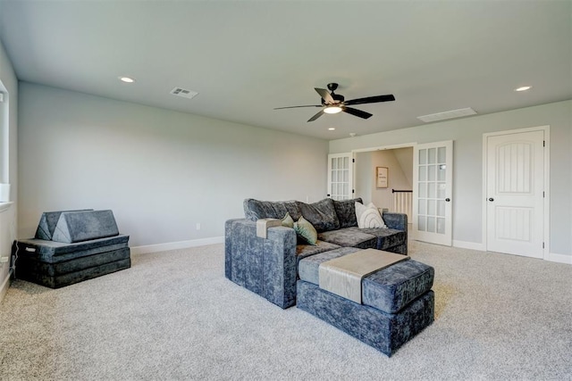 living room featuring ceiling fan, light colored carpet, and french doors