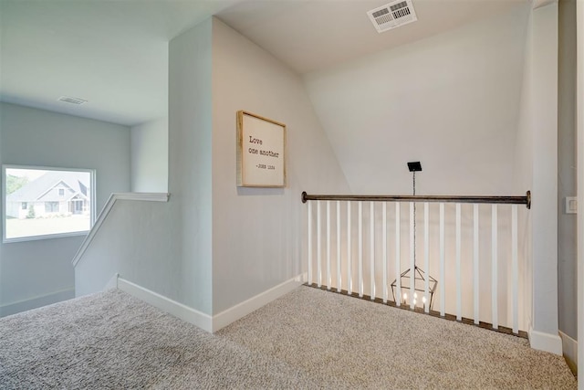 corridor featuring carpet flooring, a chandelier, and vaulted ceiling